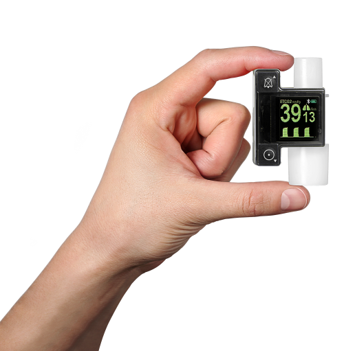 A hand holding the Masimo EMMA product