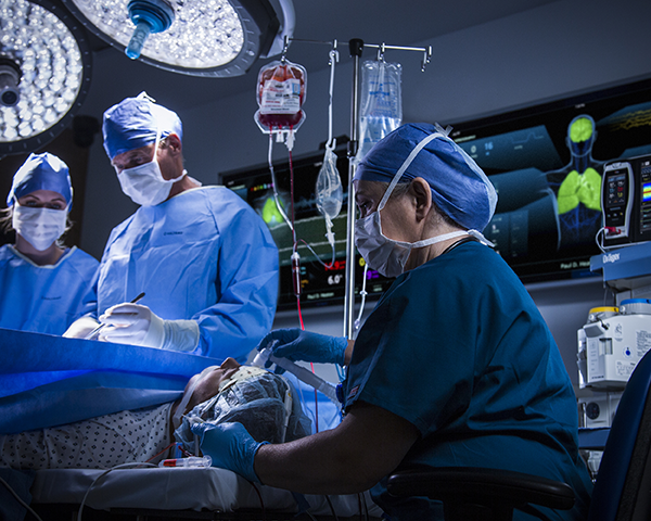 Clinicians operating on patient with UniView in the background of the operating room
